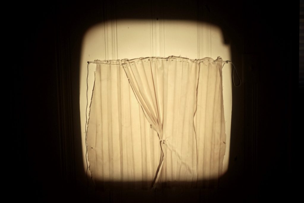 White curtains illuminated by a square of light