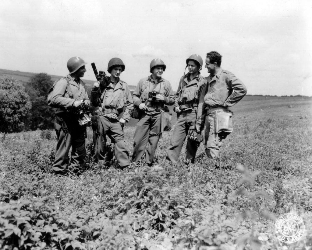 group of young man in army dress holding cameras in a hill