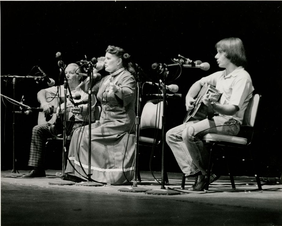 Three musicians playing instruments on a stage