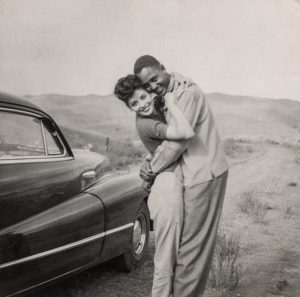 Couple hugging next to car
